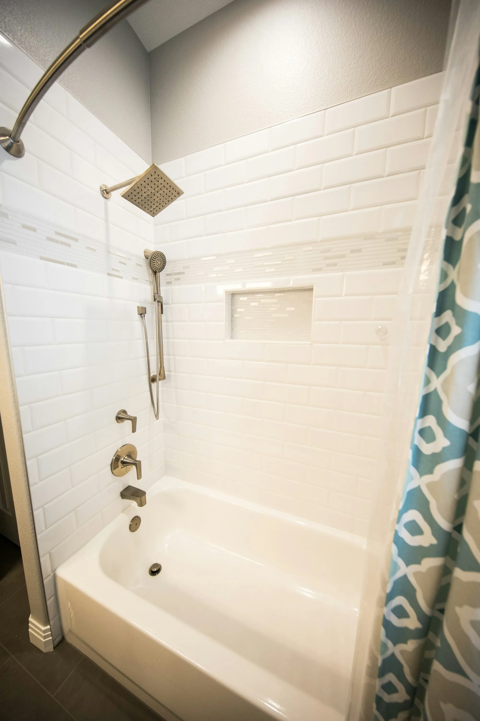 Tub and shower with white subway tile and a rainfall shower head