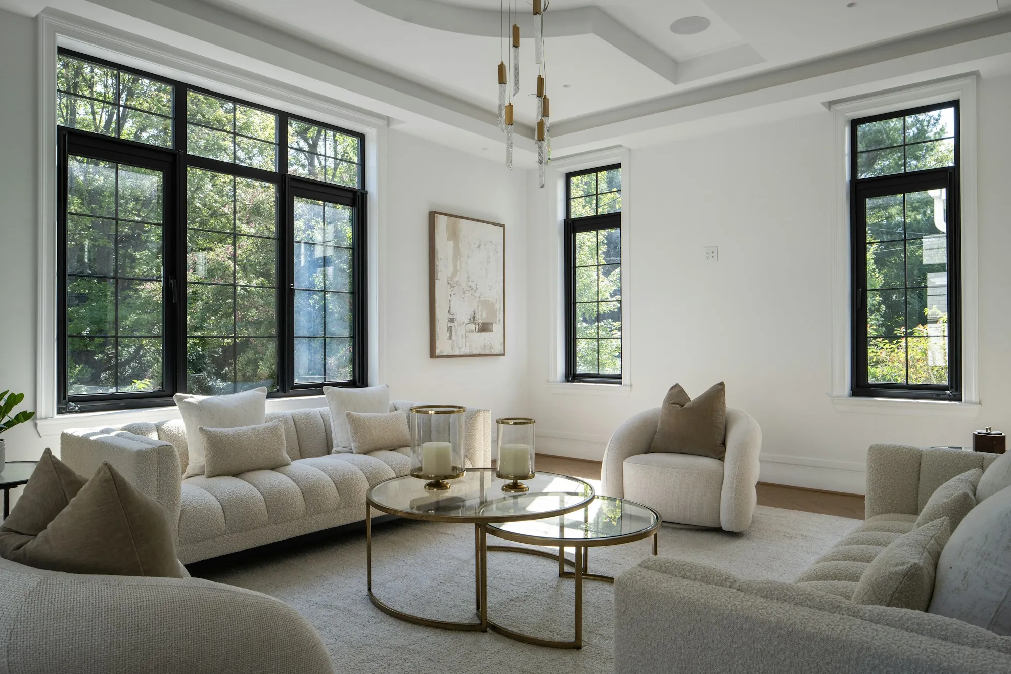 Renovated living room with tall black-framed windows and cream sofas